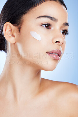 Buy stock photo Woman, face and skincare moisturizer in cosmetics or beauty against a blue studio background. Female cheek with product, lotion or cream for facial treatment, collagen or healthy self care skin