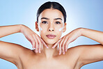 Woman, face and hands in skincare moisturizer, cosmetics or beauty against a blue studio background. Portrait of female cheeks with cosmetic product, lotion or cream for facial treatment or self love