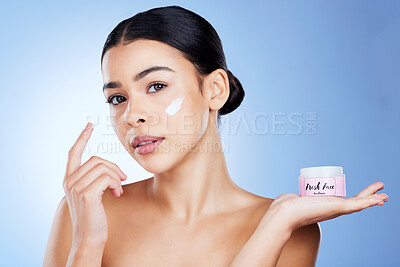 Buy stock photo Skincare, beauty and portrait of a woman with cream isolated on blue background in a studio. Cosmetic, treatment and girl applying a lotion, sunscreen or moisturizer on face for promotion with space