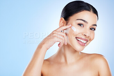 Buy stock photo Woman, face and smile for skincare moisturizer, cosmetics or beauty against a blue studio background. Portrait of happy female smiling with product, lotion or cream for facial treatment on mockup