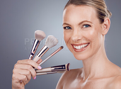 Buy stock photo Face, tools for makeup and woman with smile, beauty and skin glow, portrait and foundation on studio background. Powder, cosmetics brush and skincare with shine, cosmetology and cosmetic care