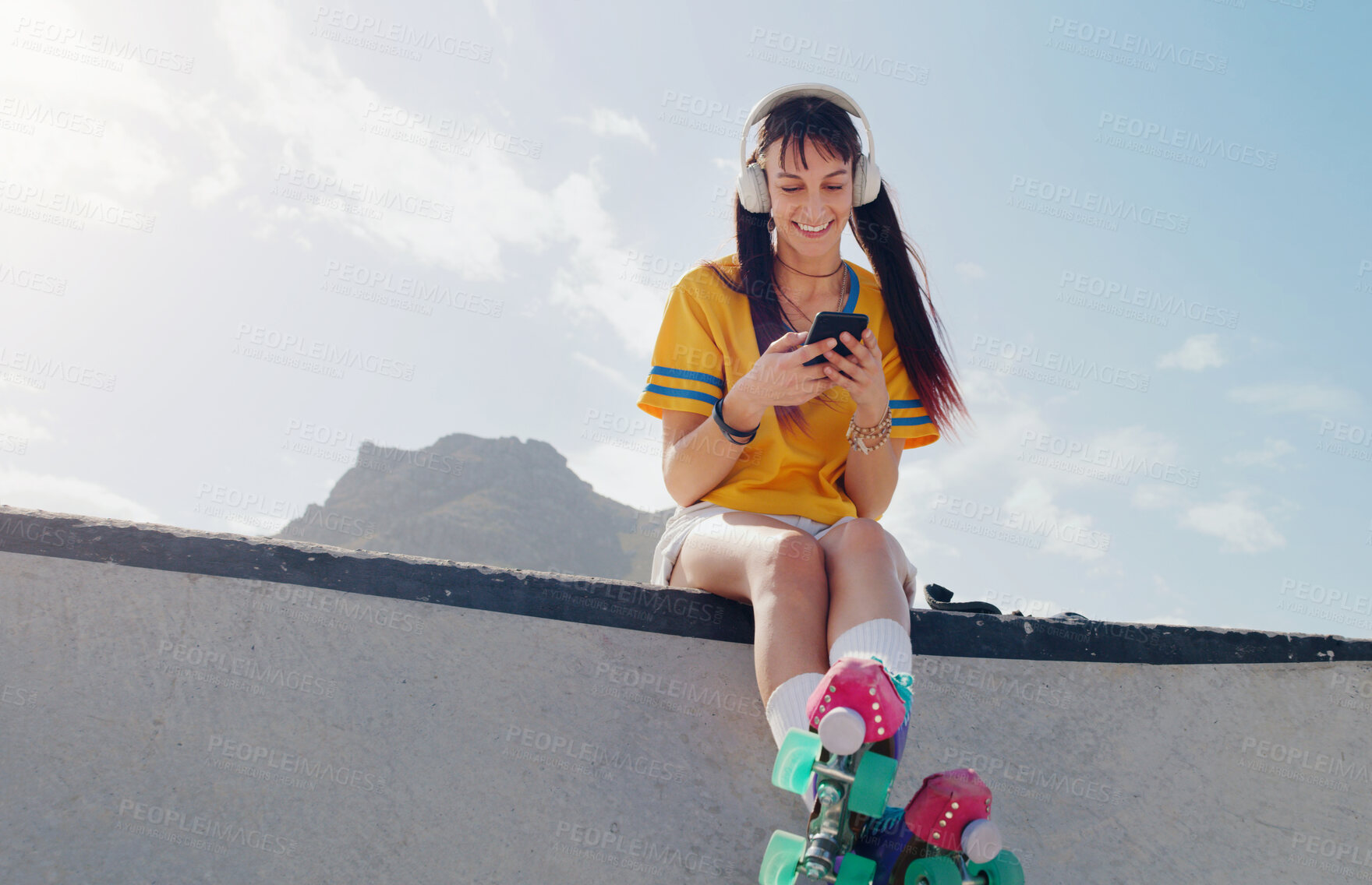 Buy stock photo Relax, phone and music with woman and rollerblades for skating, streaming and social media app. Technology, headphones and sports with girl in skate park for internet, mobile radio and fitness