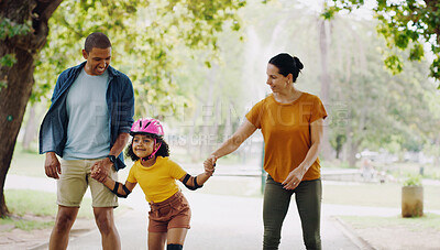 Buy stock photo Parents, park and holding hands to rollerskate with girl child with care, learning and support. Interracial family, black man and woman with kid, smile and helping hand for skating on outdoor holiday