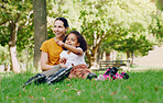 Family, mother and child in park with rollerblading outdoor, relax on grass and fun in nature with happy people. Woman, girl and taking a break, sports and quality time together with love and care