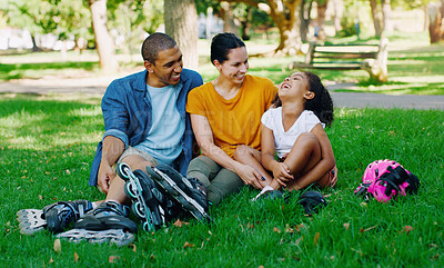 Buy stock photo African family, girl and park with rollerblades, interracial bonding and laugh for comic joke, happy or holiday. Black man, woman and child with happiness, care and diversity on grass for vacation