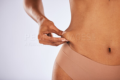 Buy stock photo Fat, lose weight and woman touching stomach in studio with liposuction mockup, space and background. Skin, cellulite and hands check muscle, body and diet for abdomen, wellness health and tummy tuck