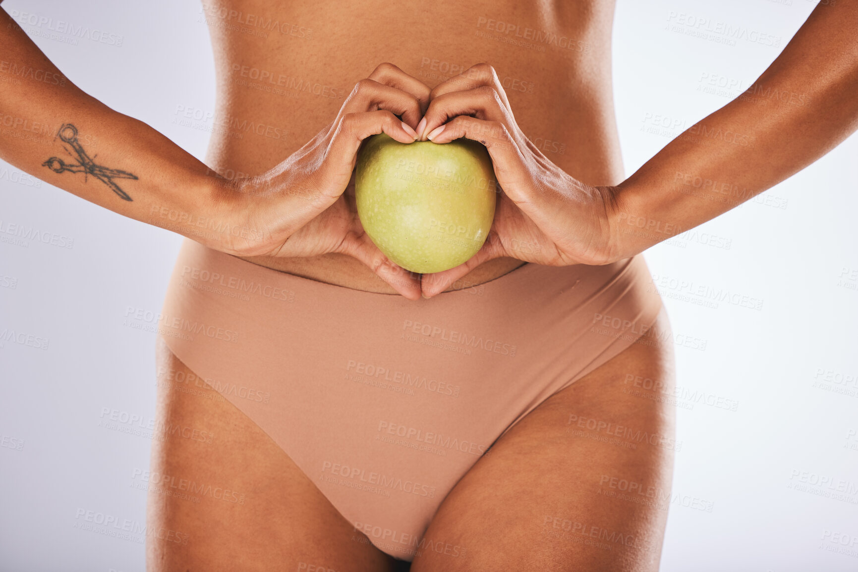 Buy stock photo Woman hands, studio and apple in heart sign on diet, wellness or lose weight by gray background. Model, fruit and stomach for healthcare, digestion or nutrition with lifestyle choice for clean eating