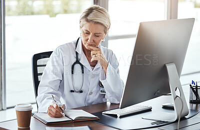 Buy stock photo Senior woman, doctor and writing in book by office desk for healthcare research, notes or planning. Elderly female medical professional thinking with notebook by computer for health strategy or plan