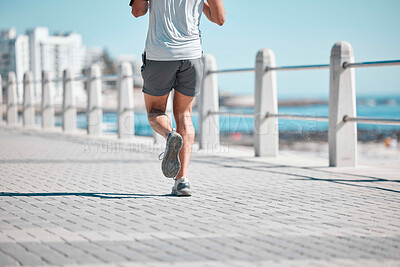 Buy stock photo Fitness, legs and man running by ocean in action for wellness, run performance and athlete endurance. Movement, motivation and male runner by sea for exercise, marathon training and cardio workout