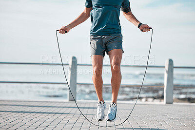 Buy stock photo Jump rope, fitness and man by a sea promenade with training, sports and exercise equipment. Health, jumping and body wellness of a athlete doing cardio jump for active lifestyle by the ocean