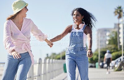 Buy stock photo Laughing, holding hands and happy girl friends back on outdoor promenade with balance and skating. Woman, skate and friendship of women on summer holiday break doing a rollerskate activity with smile