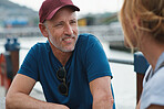 Mature man chatting to wife having conversation sitting by table in harbour watefront