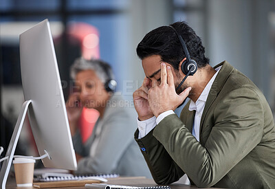 Buy stock photo Stress, customer service and a man consultant working in a call center while suffering from a headache. Burnout, telemarketing and a male consulting while feeling frustrated or tired of support