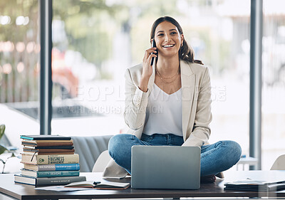 Buy stock photo Woman, laptop and phone call and sitting on desk in relax startup, marketing company or advertising business. Smile, happy and talking worker on mobile communication technology, laptop or books study