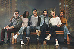 Diversity, friendship and portrait of people with a city background sitting together. Happy, smile and multiracial young friends hugging or embracing on a bench with support, unity and community.