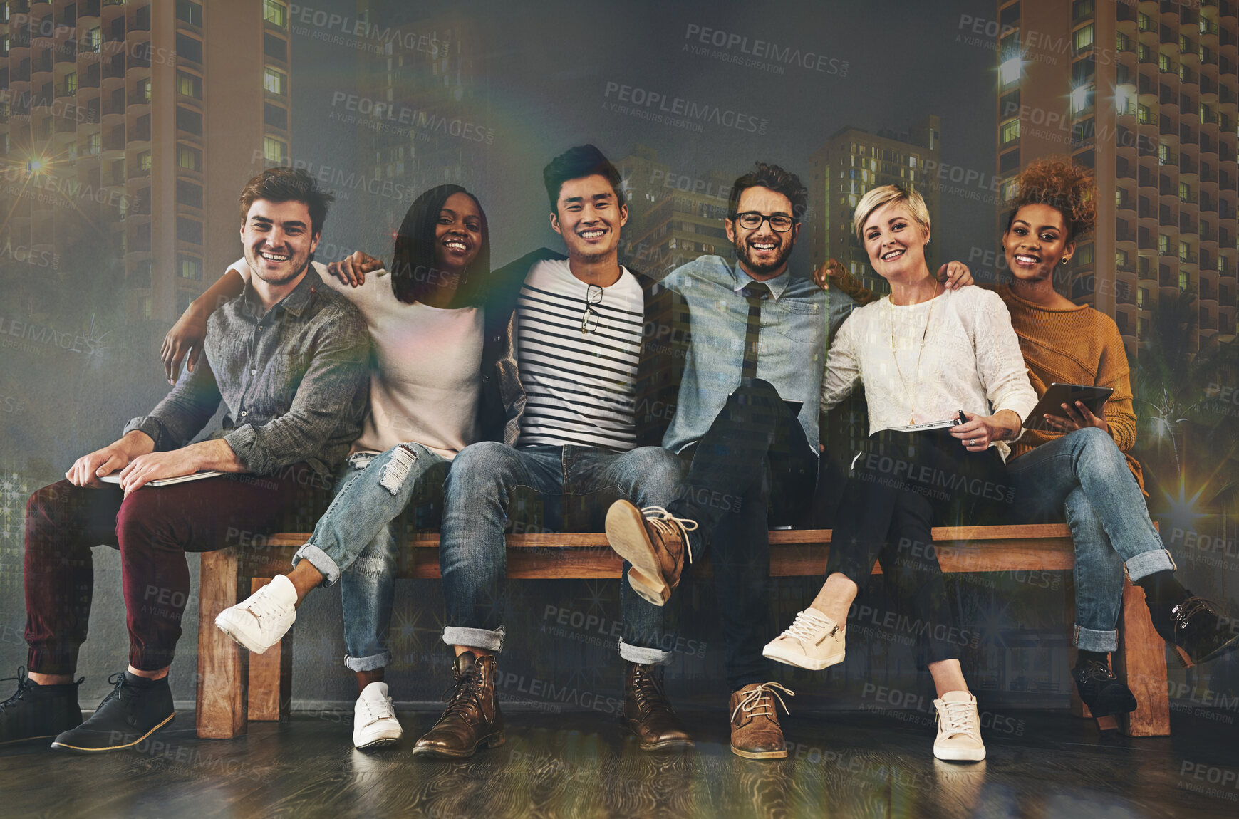 Buy stock photo Diversity, friendship and portrait of people with a city background sitting together. Happy, smile and multiracial young friends hugging or embracing on a bench with support, unity and community.