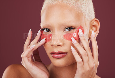 Buy stock photo Portrait, eye mask and antiaging with a model black woman in studio on a red background for skincare. Face, skin and beauty with an attractive young female posing to promote a cosmetic product