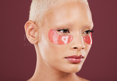Buy stock photo Eye patches, skincare and cosmetics of black woman doing face cleaning and wellness facial. Beauty, skin glow and mockup of a young model in a studio for dermatology, collagen and self care treatment