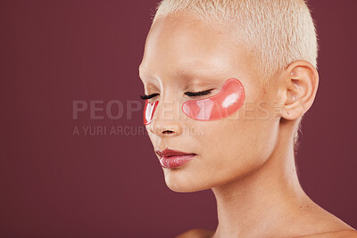 Buy stock photo Eye patches, skincare and beauty of black woman doing face cleaning and wellness facial. Calm, skin glow and mockup of a young model in a studio for dermatology, collagen with maroon background