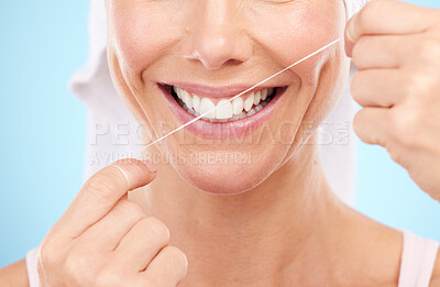 Buy stock photo Floss, dental wellness and mouth of woman in studio for beauty, healthy face and happiness on blue background. Closeup model, tooth flossing and cleaning for facial smile, mint breath and happy teeth
