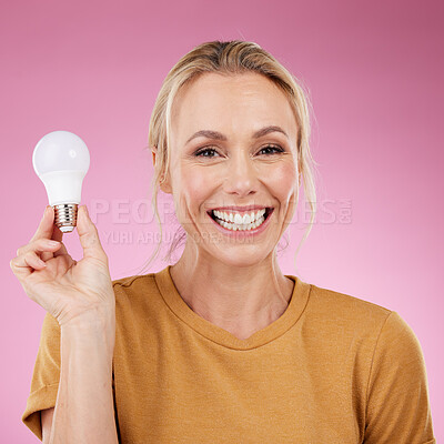 Buy stock photo Lightbulb, portrait and woman isolated on pink background for beauty ideas, inspiration or cosmetics solution. Happy model or mature person with light bulb thinking of dermatology, skincare or health