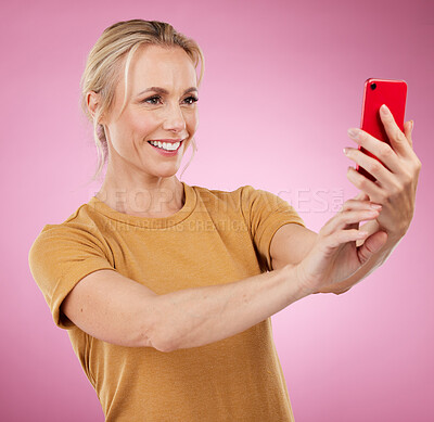 Buy stock photo Selfie, happy and woman with a phone in the studio with a positive, optimistic and good mindset. Happiness, smile and female model from Canada taking a picture on a cellphone by a pink background.