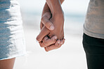 Closeup, love and couple holding hands at a beach for fun, travel and bonding on blurred background. Zoom, hand and man with woman for ocean getaway, close and romantic break together in Mexico