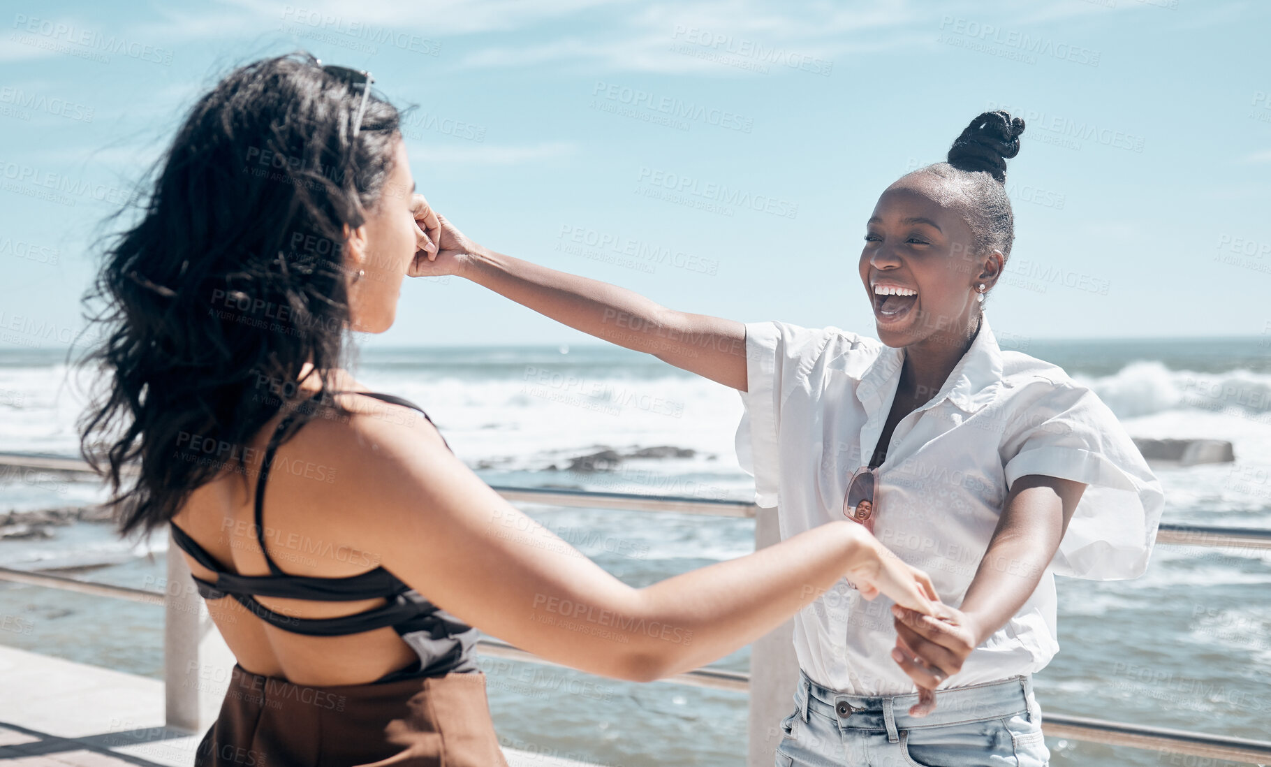 Buy stock photo Friends, holding hands and women dance at beach, having fun and laughing together outdoors. Comic, freedom and girls laugh at funny comedy or joke, dancing and enjoying time at promenade seashore.