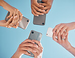 Hands, phone and people networking below on social media or mobile app with blue sky background. Low angle hand of group with smartphone in circle for online share, data sync or team communication