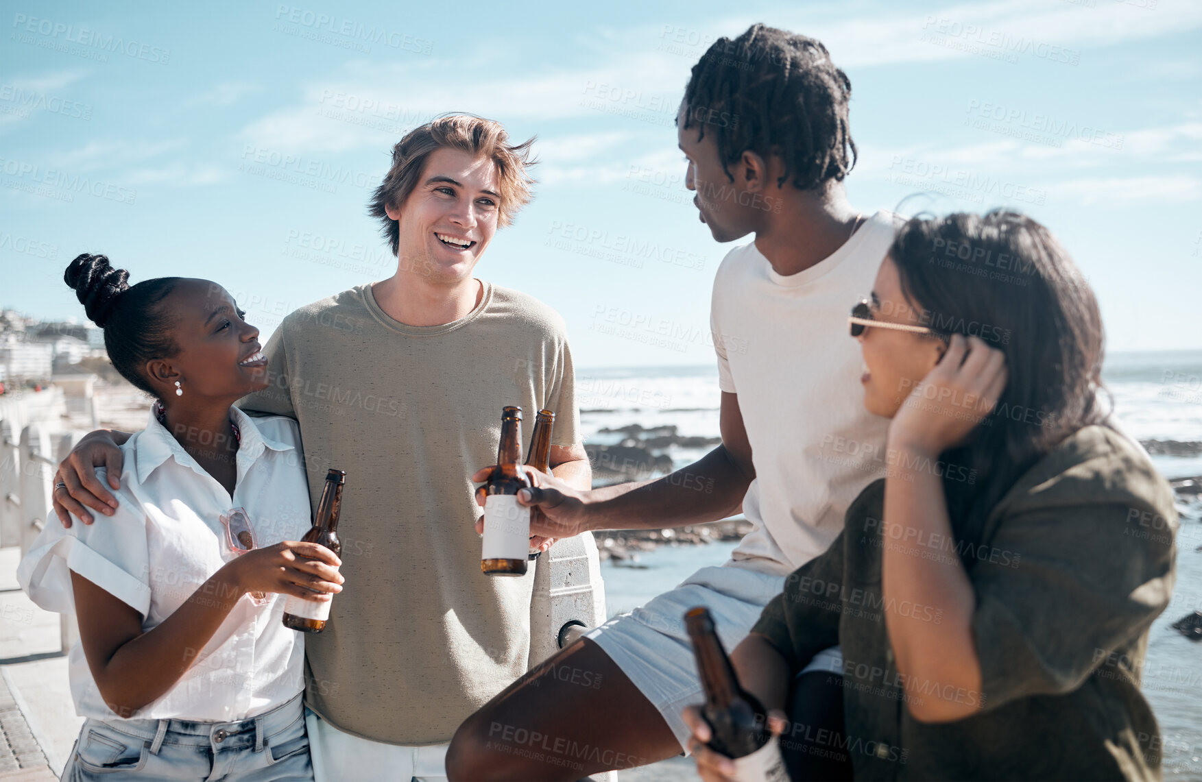 Buy stock photo Couple of friends, talking or drinking beer by beach, ocean or sea in holiday vacation, summer travel or social gathering. Smile, happy or bonding people and alcohol drinks for diversity celebration