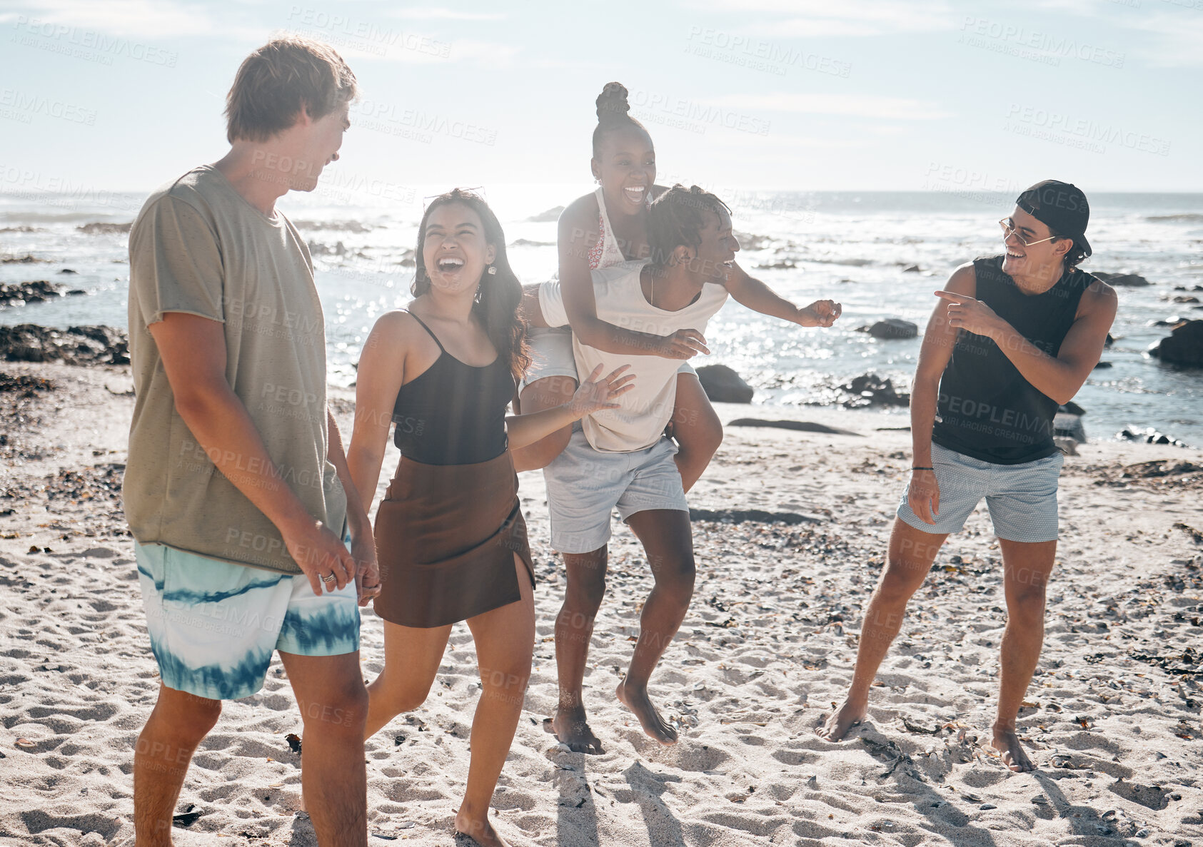 Buy stock photo Friends, laughing or piggyback by beach, ocean or sea in social gathering, group vacation comedy or summer holiday. Smile, happy or diversity men carrying women in travel fun, bonding or comic games