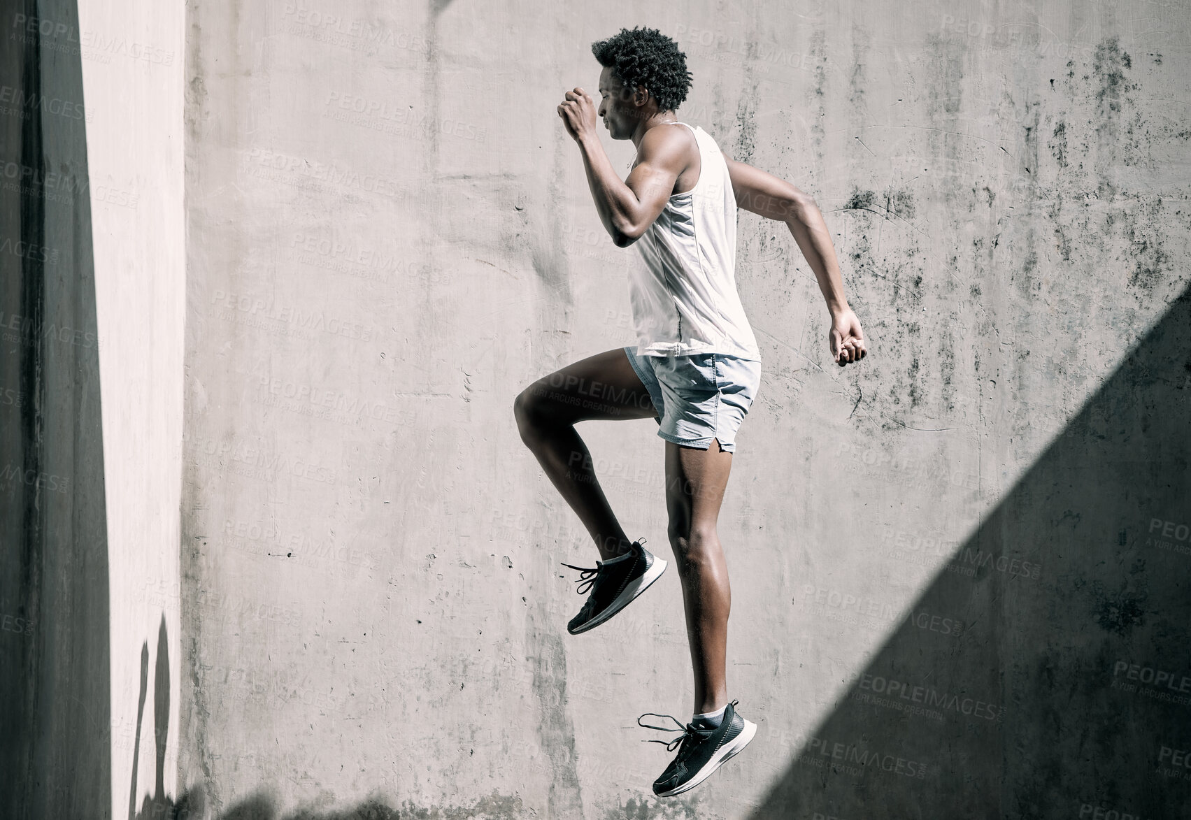 Buy stock photo Exercise, fitness and black man jump in city for health, wellness and energy against wall mockup. Sports, training and male athlete jumping, workout or exercising for endurance, practice or strength.