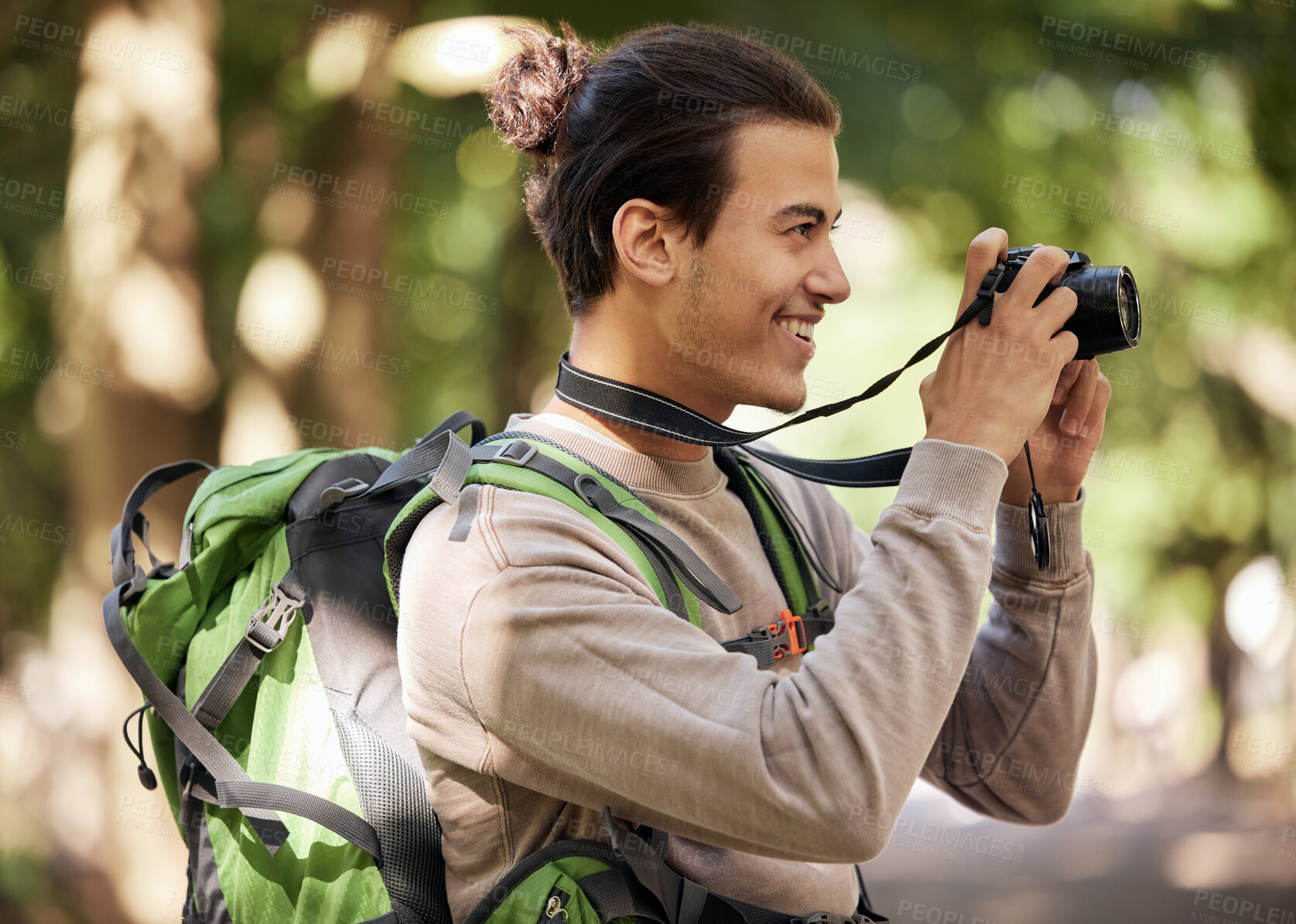 Buy stock photo Photographer man, camera and outdoor park with smile, focus or adventure with creative vision. Young nature journalist, photography expert and bird watching with tech, hiking or backpack for research