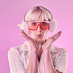 Fashion, portrait and a woman quirky in studio for wow, surprise and comic face on pink background. Aesthetic model person with glasses and earmuffs for edgy vaporwave trend with creativity and color