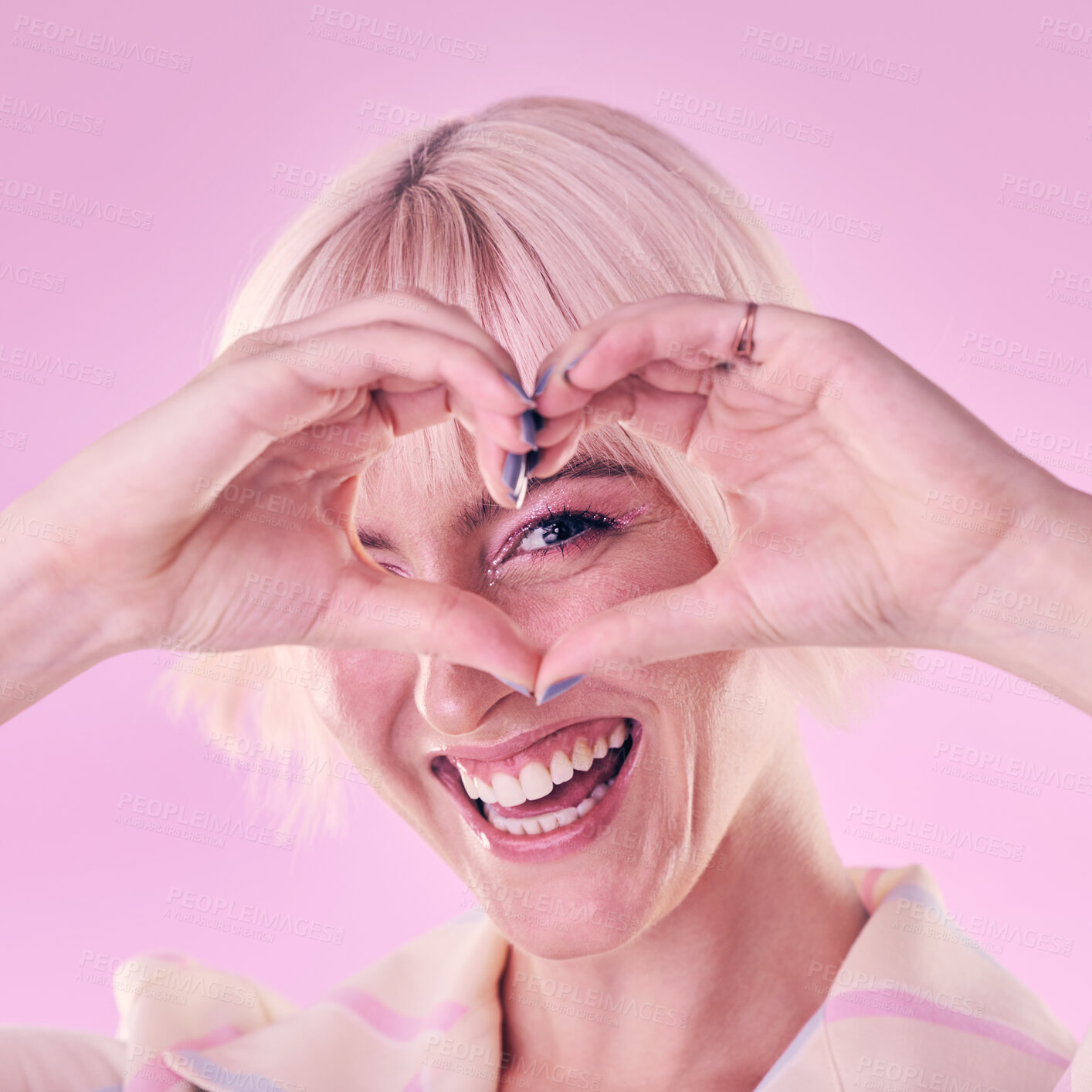 Buy stock photo Portrait, woman and hands with heart, smile and freedom with confident girl against studio background. Face, female hipster and lady with gesture for love, emoji and support with style and trendy