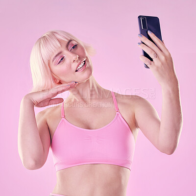 Buy stock photo Selfie, beauty and woman in a studio with a makeup or cosmetic face routine with a cellphone. Cosmetics, style and female model from Australia taking a picture on a phone isolated by pink background.