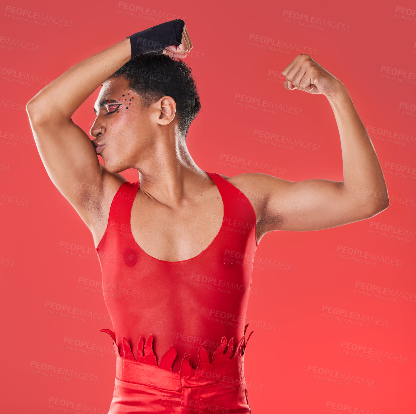Buy stock photo Man, studio and arm muscle kiss with wrestling, punk costume and makeup for lgbt aesthetic by red background. Young bodybuilder, gen z gay and fitness with strong body, self care and pride for health