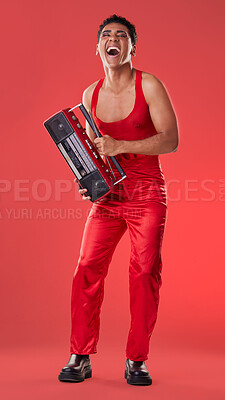Buy stock photo Radio, laughing and red background with a gen z man in studio listening to music for carefree fun. Transgender, non binary and laughter with a young androgynous or gay person posing for inclusion