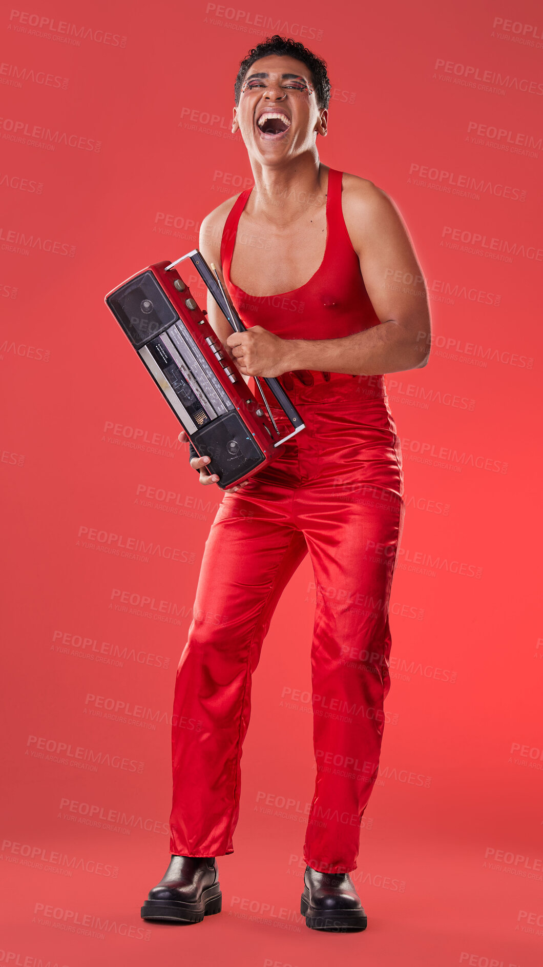 Buy stock photo Radio, laughing and red background with a gen z man in studio listening to music for carefree fun. Transgender, non binary and laughter with a young androgynous or gay person posing for inclusion