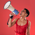 Anger, gay and a man with a megaphone for expression isolated on a red background in a studio. Decision, freedom and person shouting and talking into a speaker while pointing with choice on backdrop