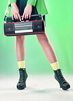 Radio, woman and music with retro technology and fashion, entertainment with station, funk and legs on green background. Style, vintage sound and audio equipment, female boots with broadcast device