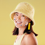 Fashion, face and woman portrait with comic eyes isolated on yellow background in a studio. Happy, funny and stylish asian girl model with a smile, color and mindset for motivation and skin cosmetics