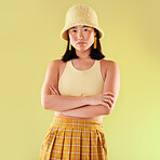 Asian, woman in portrait and fashion with yellow aesthetic, beauty and confident with arms crossed on studio background. Style, edgy and female with streetwear, trendy designer clothes and mockup