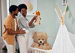 Love, pregnancy and couple with teddy bear in the nursery with excitement while preparing for their baby. Happy, smile and young African man with his pregnant wife looking at toy together in bedroom.