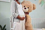 Pregnant, teddy bear and woman with hand on stomach for growth, development and bonding in room. Black person during pregnancy with stuffed animal toy for care, love and support for healthy lifestyle