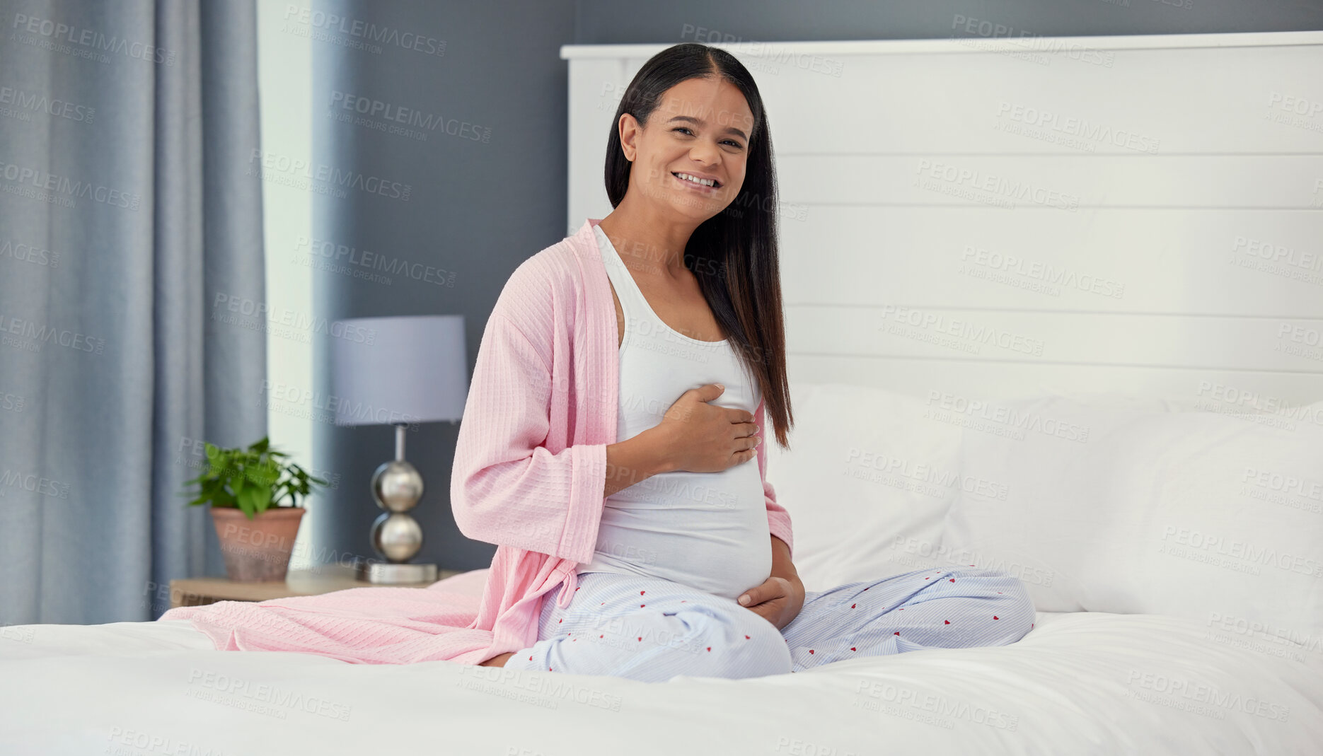 Buy stock photo Pregnant woman, portrait and stomach in home bedroom happy about bonding and growth. Mother to be person with hands on abdomen for healthy pregnancy development, body wellness and love or care on bed