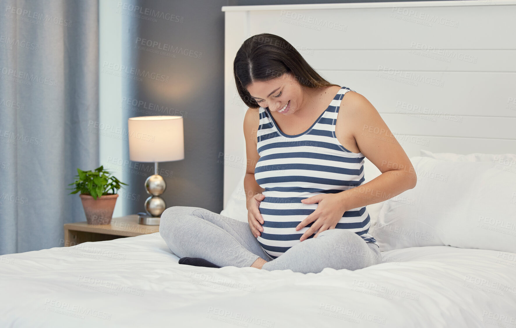 Buy stock photo Pregnant stomach, woman and home bedroom while happy about bonding and growth. Mother to be person with hands on abdomen for healthy pregnancy development, body wellness and care or love on her bed