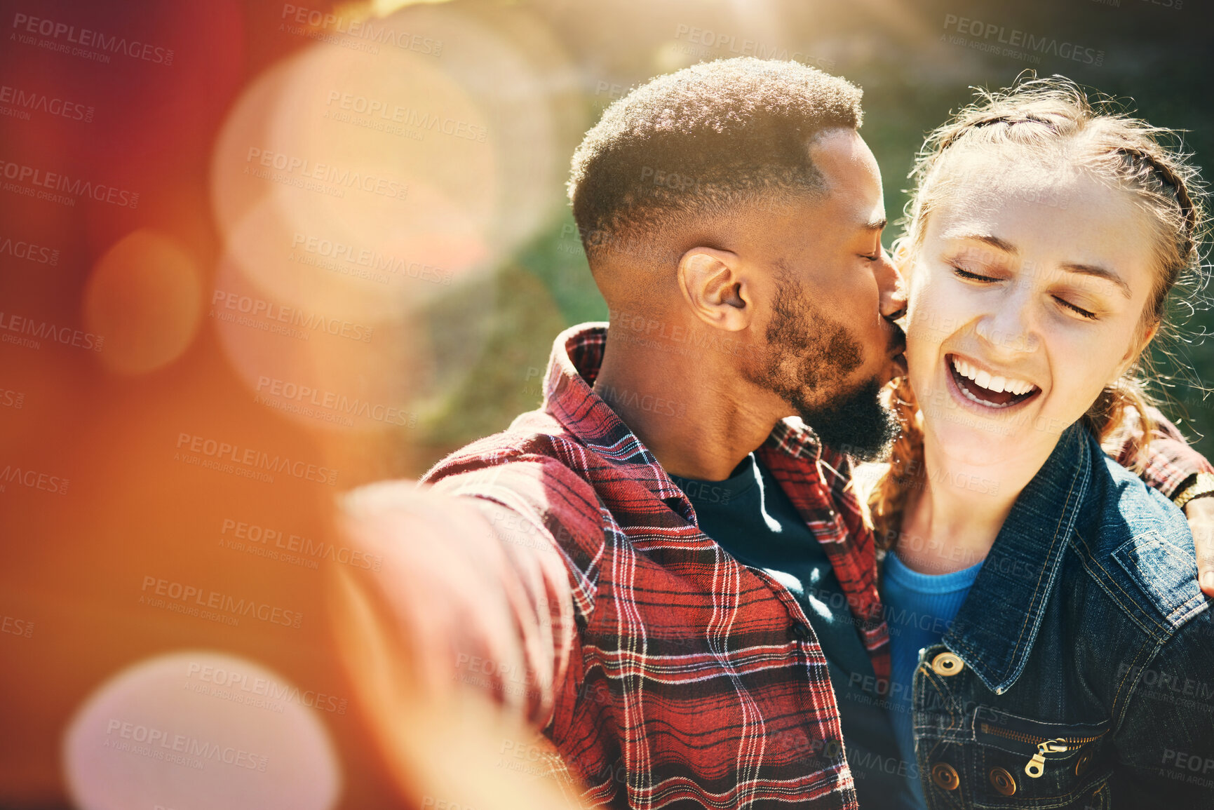 Buy stock photo Selfie, kiss and interracial couple on a date in nature for support, love and bonding in Australia. Freedom, trust and black man and woman with kissing affection, quality time and photo for memory