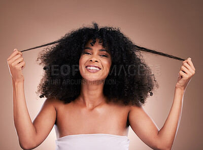 Buy stock photo Hair in hands, beauty and portrait of black woman on brown background for wellness, shine and natural glow. Salon, luxury treatment and happy girl face with curly hairstyle, texture and afro growth
