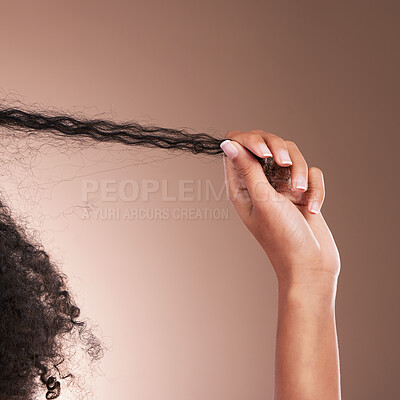 Buy stock photo Hair in hands, afro beauty and black woman on brown background for wellness, shine and natural glow. Salon, luxury treatment and hand with strand for growth with curly hairstyle, texture and care